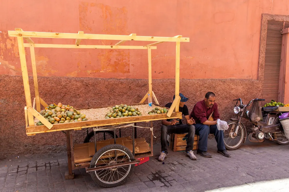 Ein Obstkarren vor einer rosafarbenen Mauer in der Medina